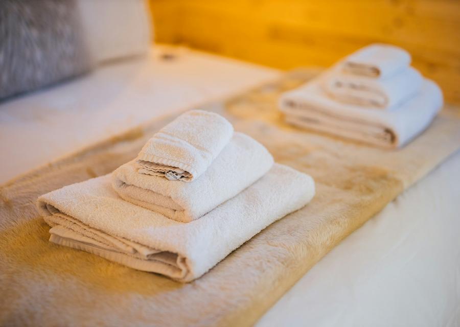 Folded towels on a bed made up for guests