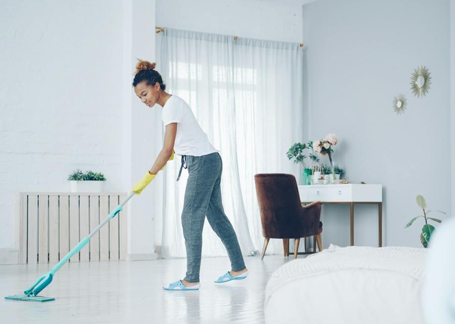 Profissional a limpar o chão de uma sala clara